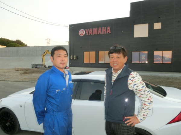 ６月オープンの新社屋前で山崎社長と…