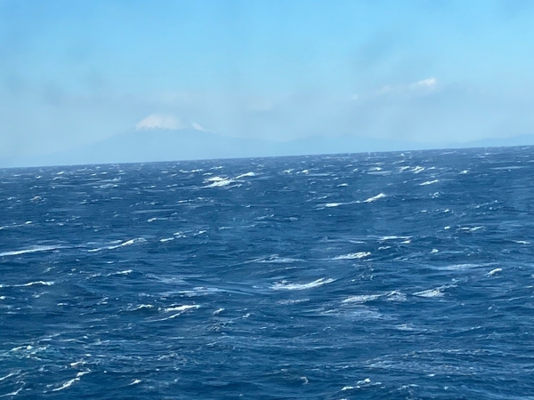 荒波のむこうにうっすら富士山